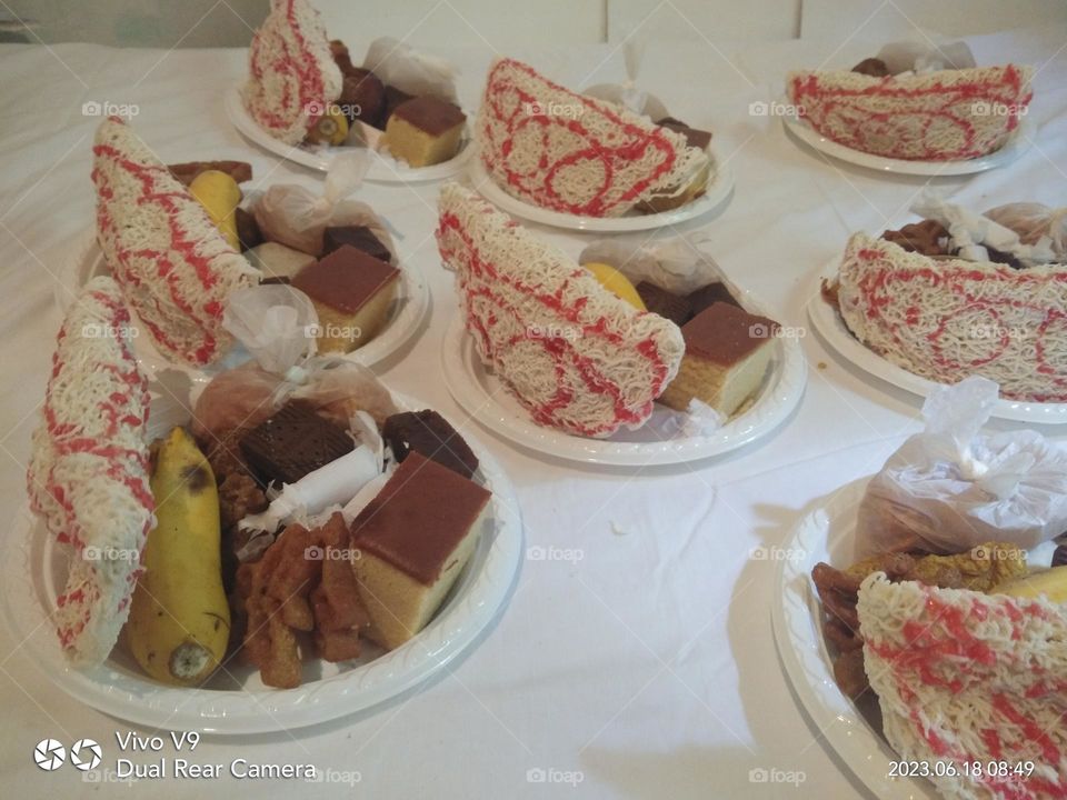 This is a plate of sweetmeats and ther are lot of traditional sweetmeats of srilanka. and also ther are some bananas and pieces of cakes on plates .ππ