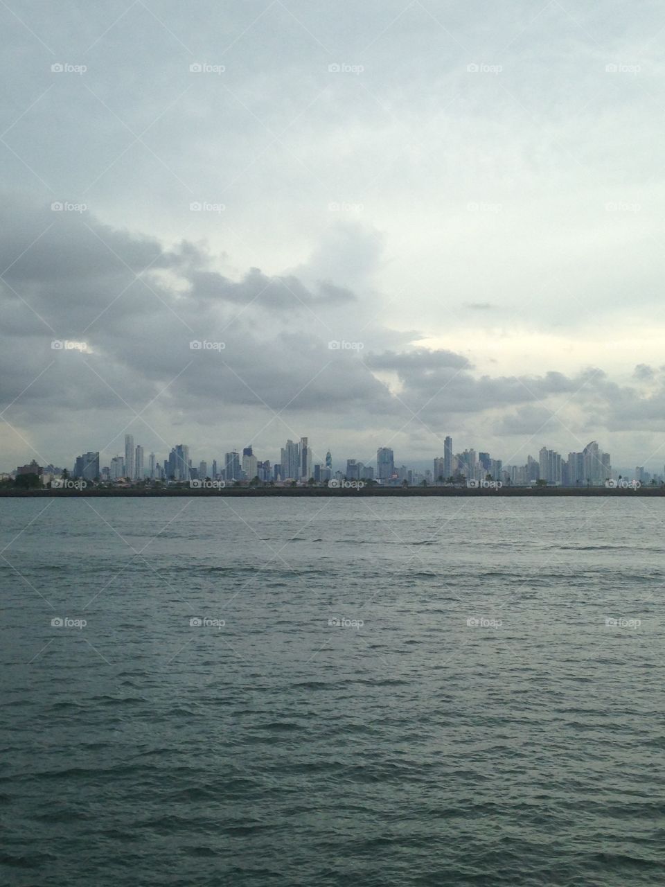 The skyline of Panama City from across the water in the section of Antigua. Clouds roll in over the buildings