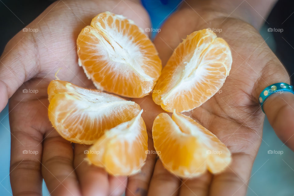 Slices of orange fruit on palm of hand