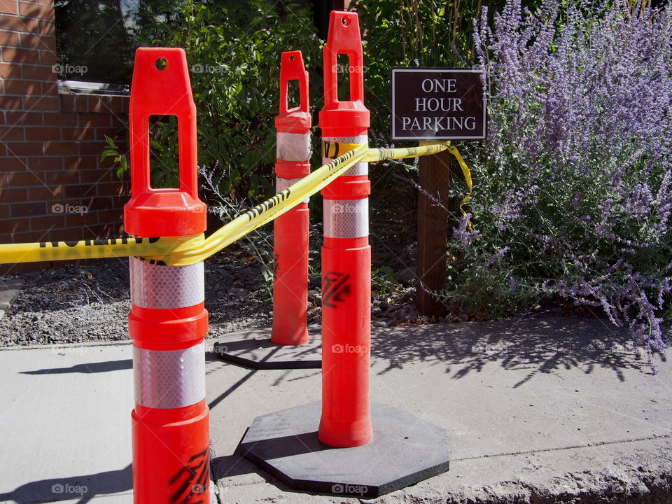 Pylons and tape keep people from walking on a newly pored sidewalk. 