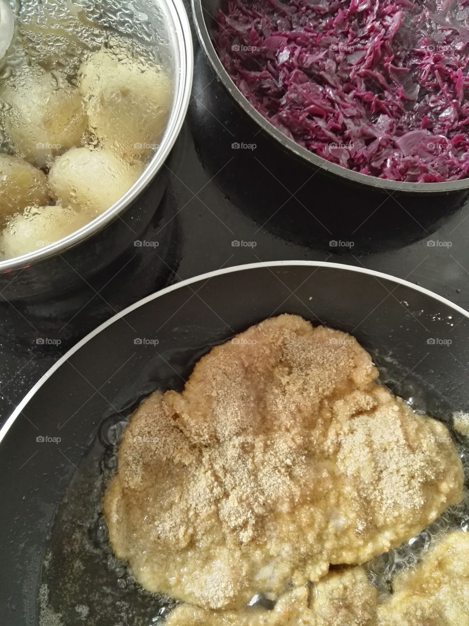 making a dinner pork chop, red cabbage, potatos