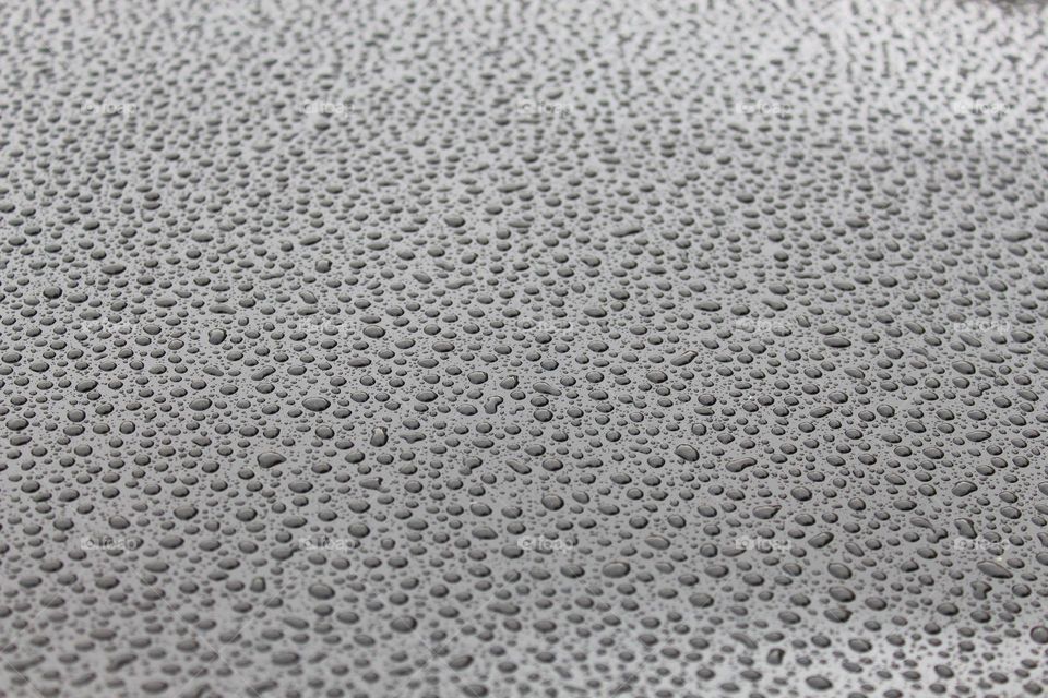 Tiny drops of rain on a gray metal surface.  Textured effects