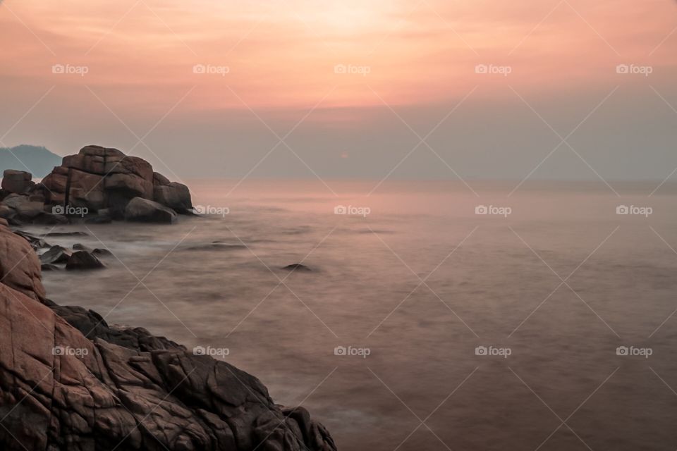 Coastal Dawn.. Combination of the Pinkish, orange color of the sky that reflects on the water with a moody seascapes. 2 minutes before the Final Rise!