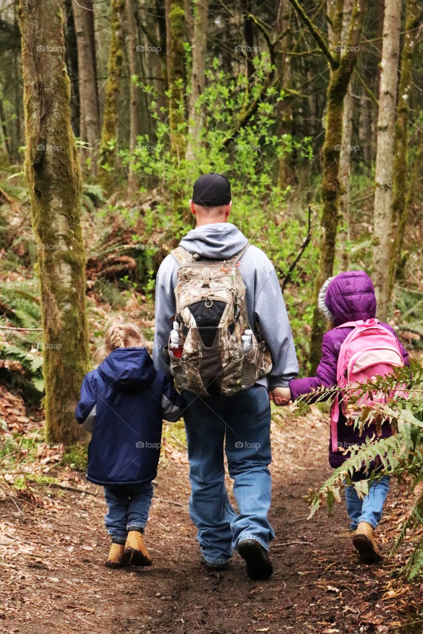 Father hiking with his daughters