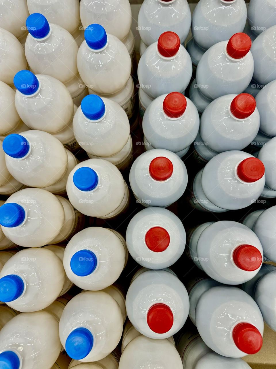 Milk bottles with red and blue caps. Shot from above