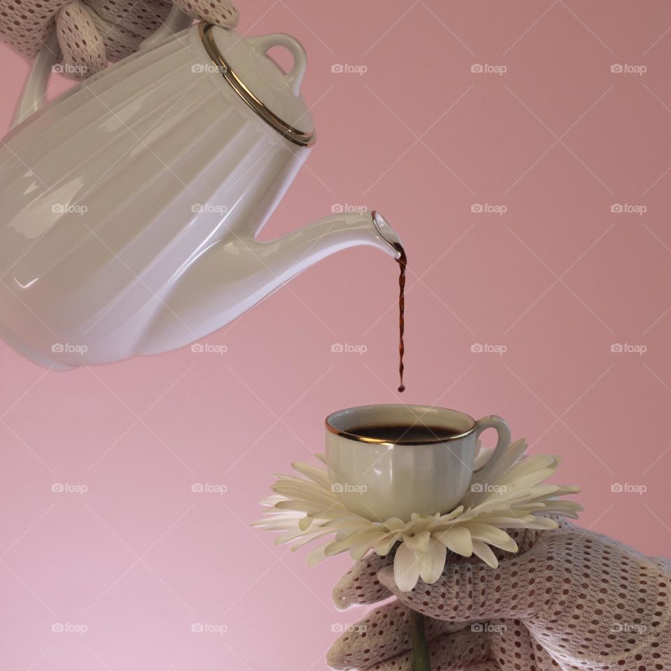 Pouring doffee with retro cup on a pink background.