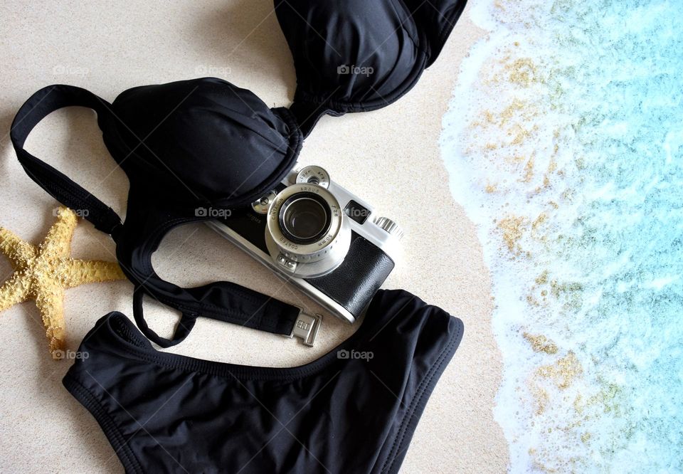 Two piece swimsuit with camera on the beach 