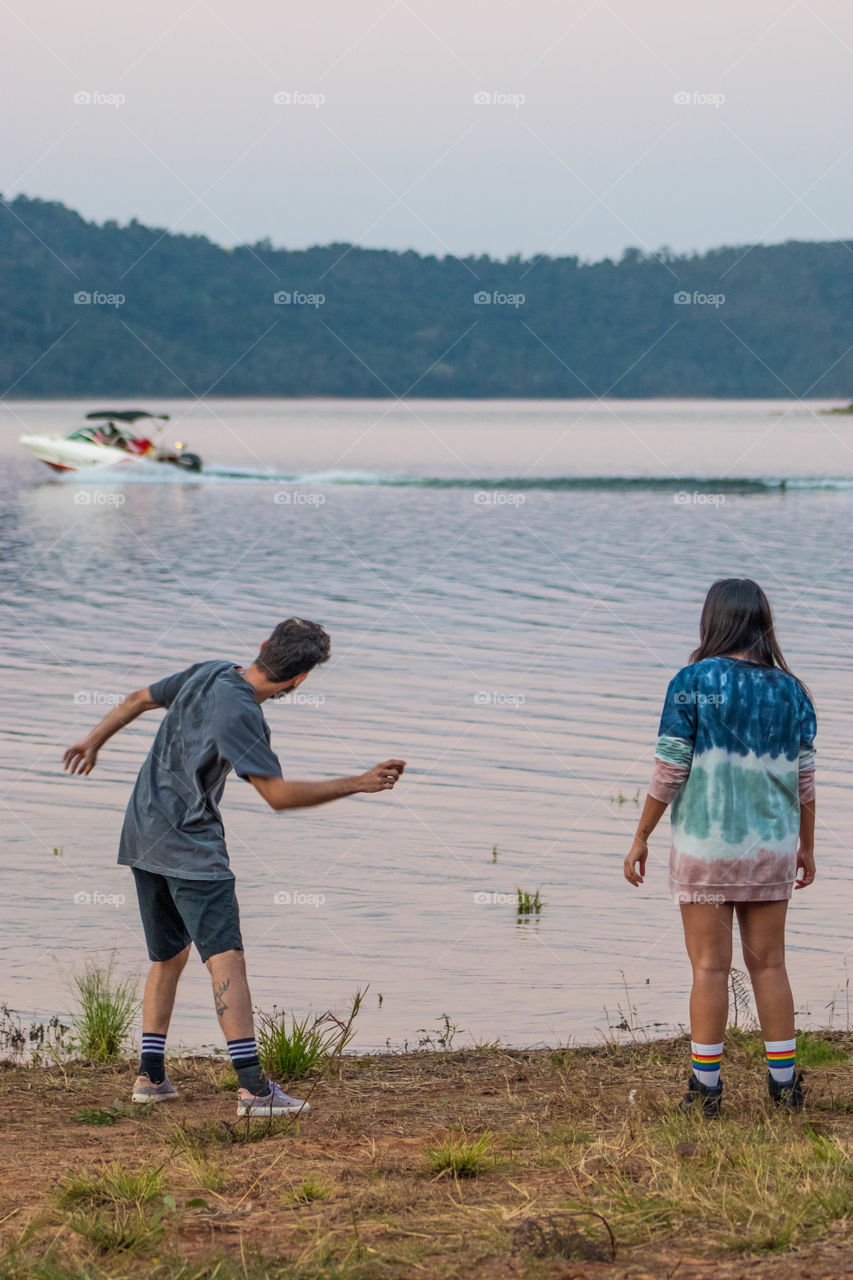 casal se divertindo na beira da represa.