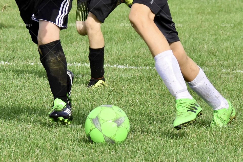 Bright green soccer ball and players with bright green shoes