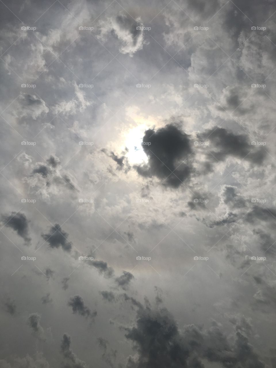 Sun behind clouds during an eclipse 