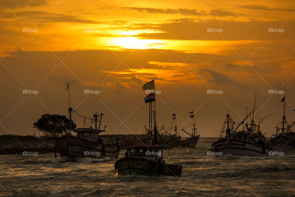 Sailboats on sea at dusk