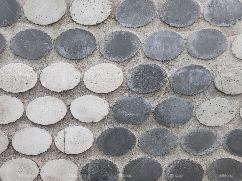 Circles in cement outdoors park bench art.