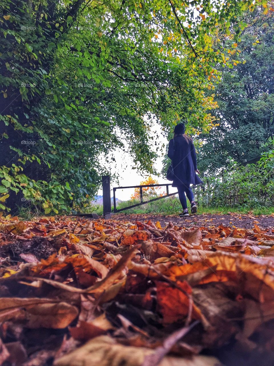 Woman walking on footpath during autumn