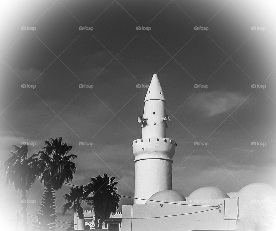 The picture shows a minaret.
it is a part of the mosque.
The minaret is used to call for prayer
This one is characterized by its cylindrical shape and height.
This minaret follows the Turkish Mosque in Houmt Souk on the island of Djerba