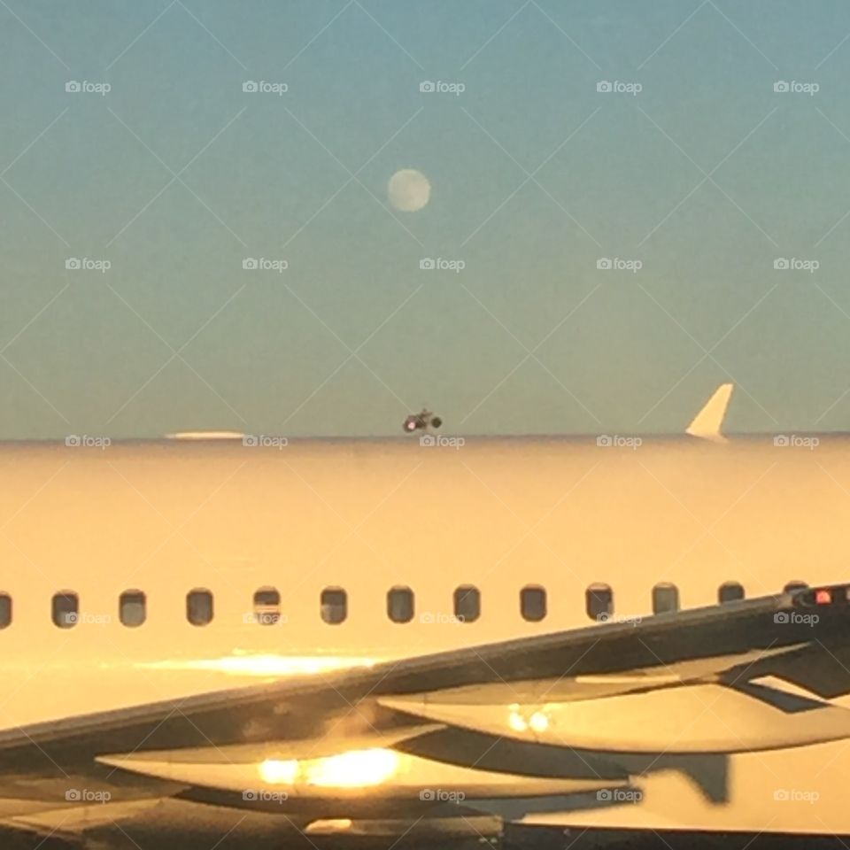 Full day moon over airplane 