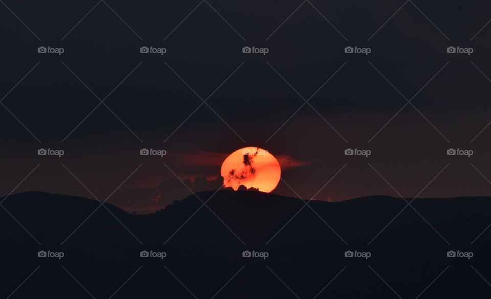 some cloud in front of sun in evening time