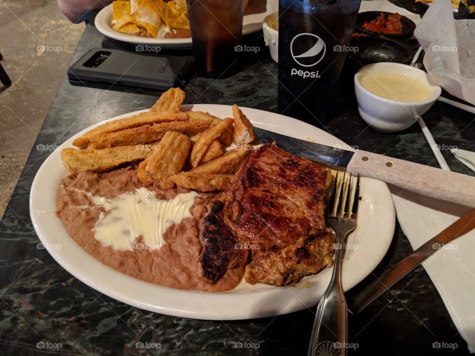 steak, potato fries, and refried beans with queso