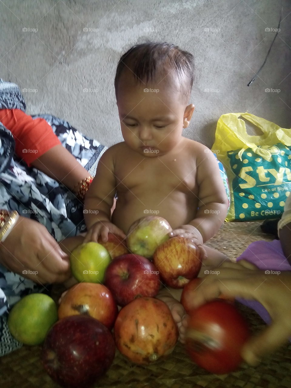 baby is so cute with some fresh fruits.