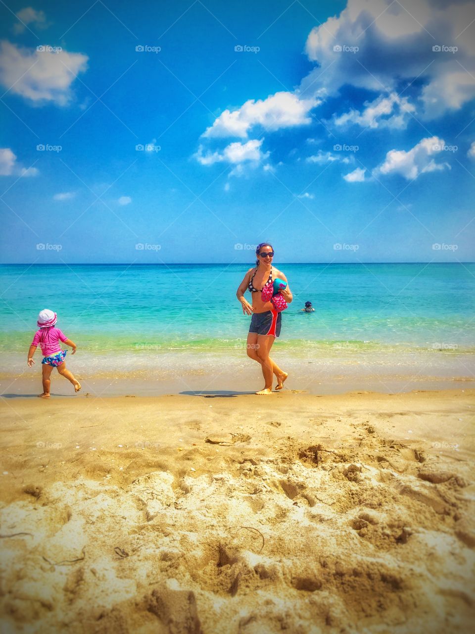 Mother and daughter walking on the beach