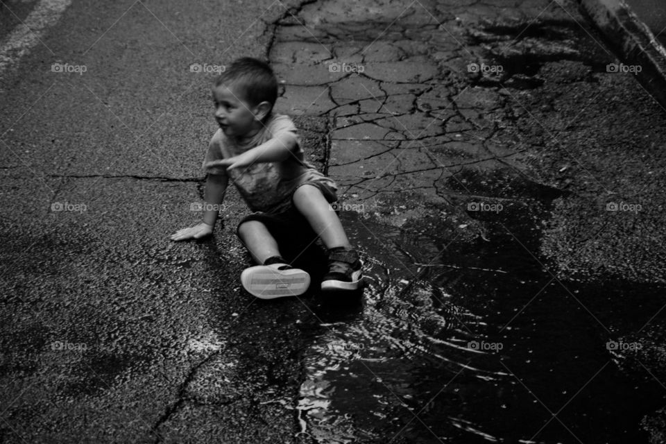 Little boy playing with water in the streets of New York 