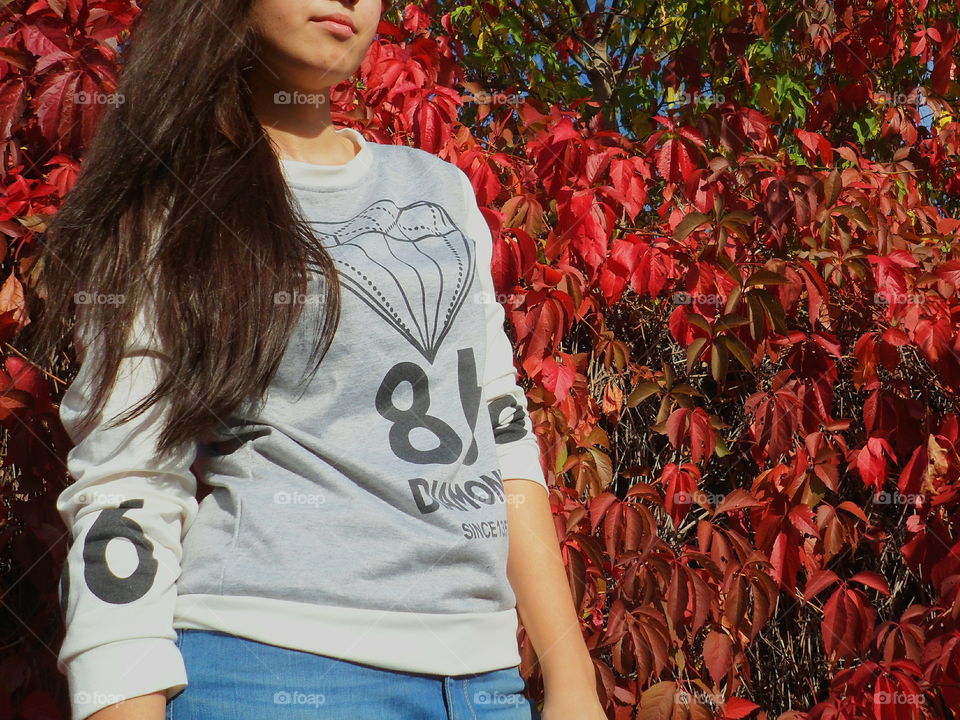 girl on a background of red autumn leaves