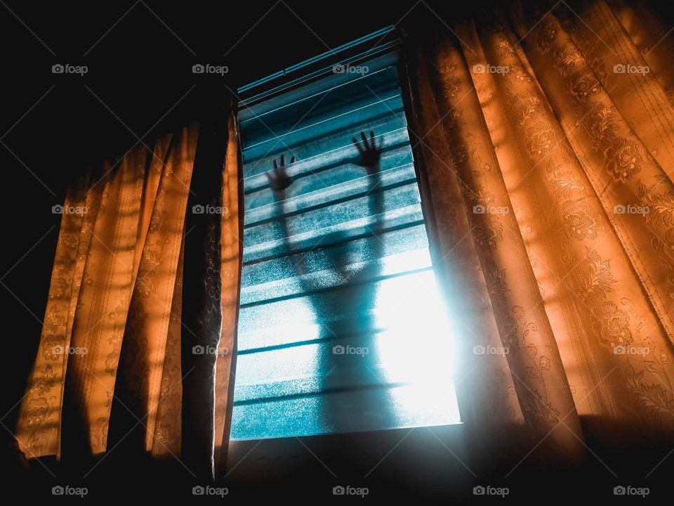Shadow of a man outside the window at night