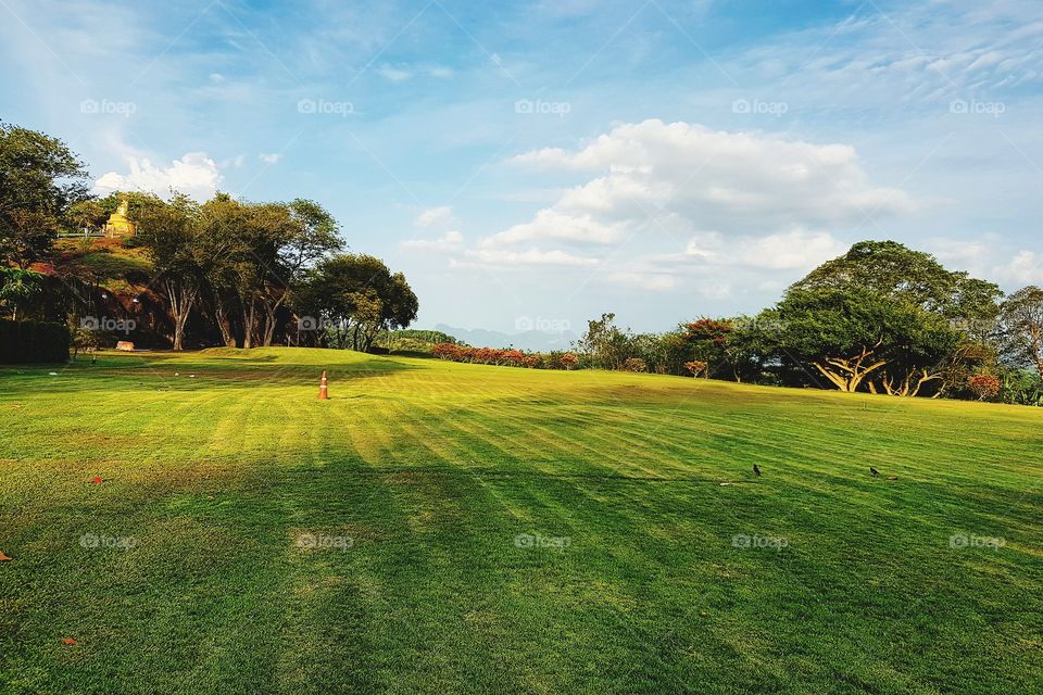 Scenic view of golf course against sky