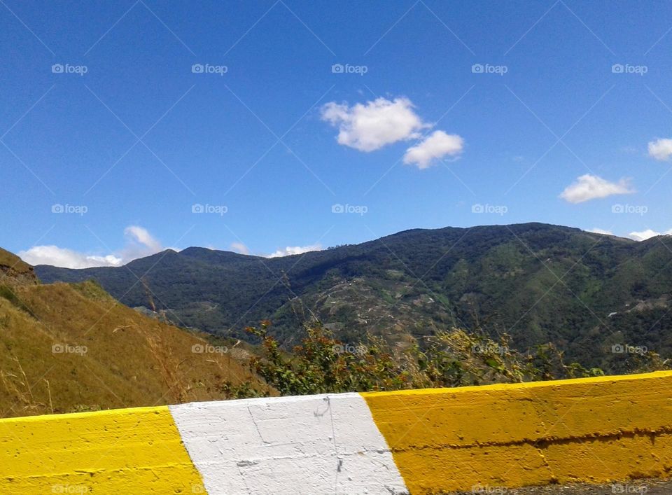 hike up the mountain looking at the sky, the surroundings, seeing the immense blue sky and the decoration of the street in an intense yellow