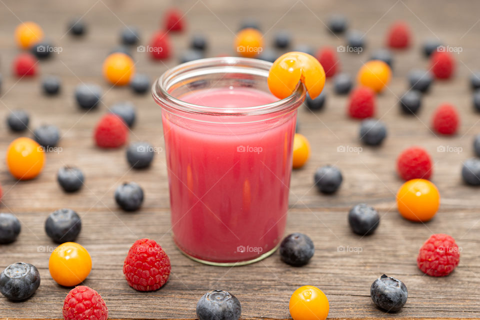 berrie smoothie in a glass and decoration around