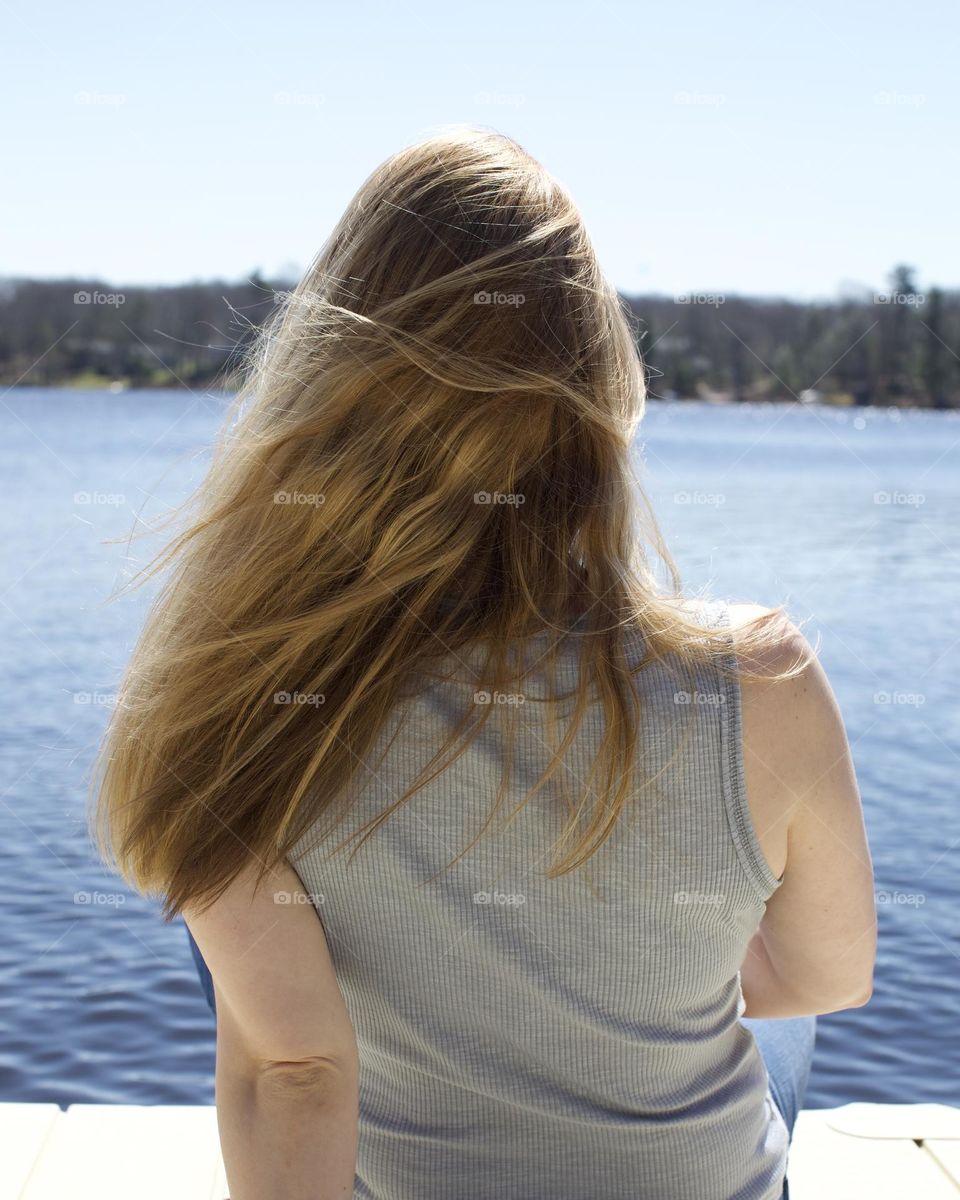 Woman’s hair blowing by the lake