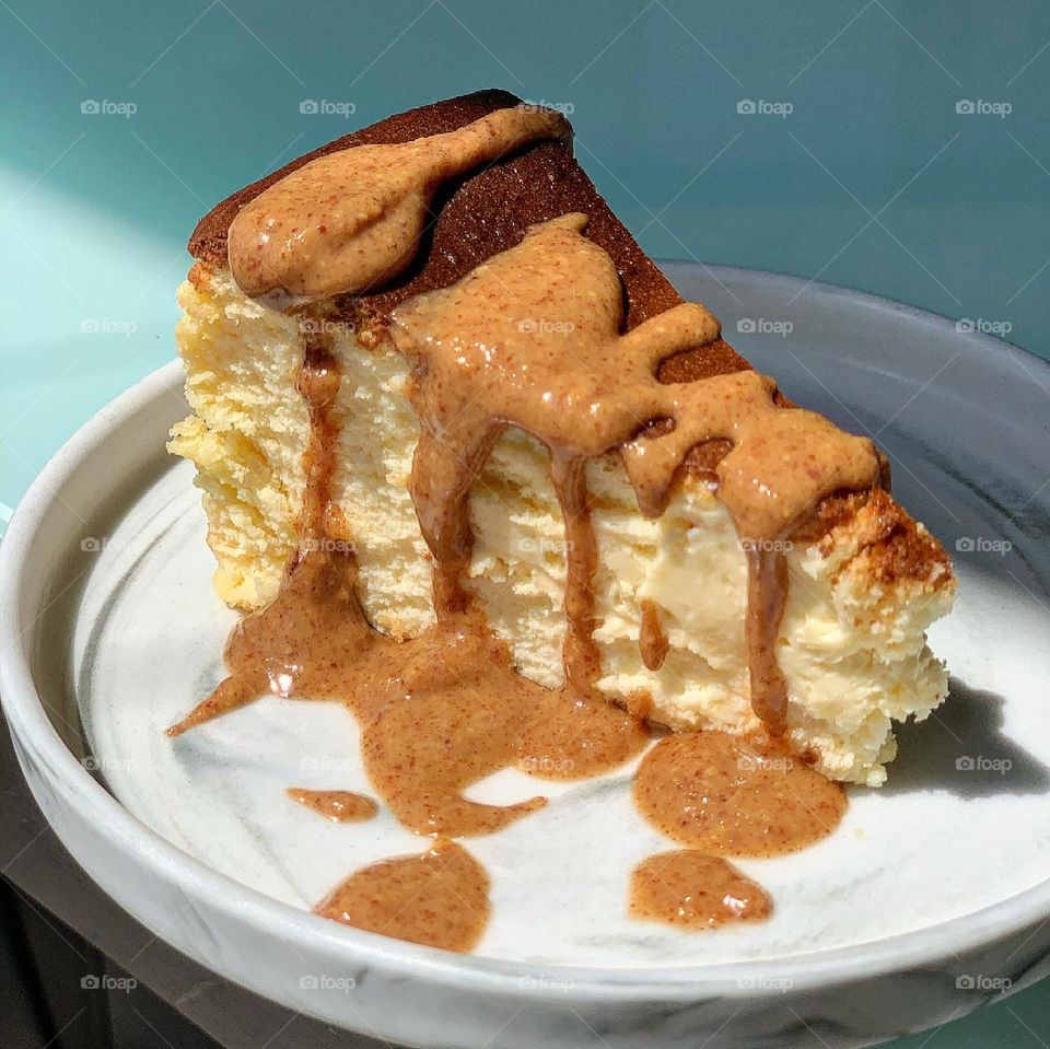 Healthy and nutritious wholesome almond nut butter drizzled on burnt cheesecake, suitable for keto diet