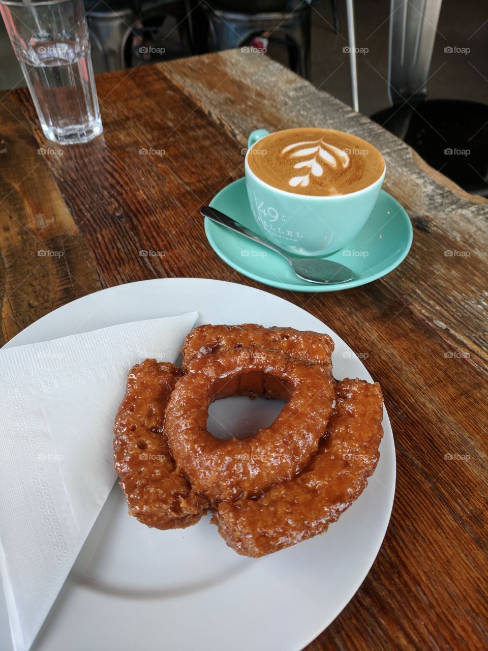 Cappuccino Coffee in Turquoise Cup and Delicious Doughnut on Reclaimed Wood Table