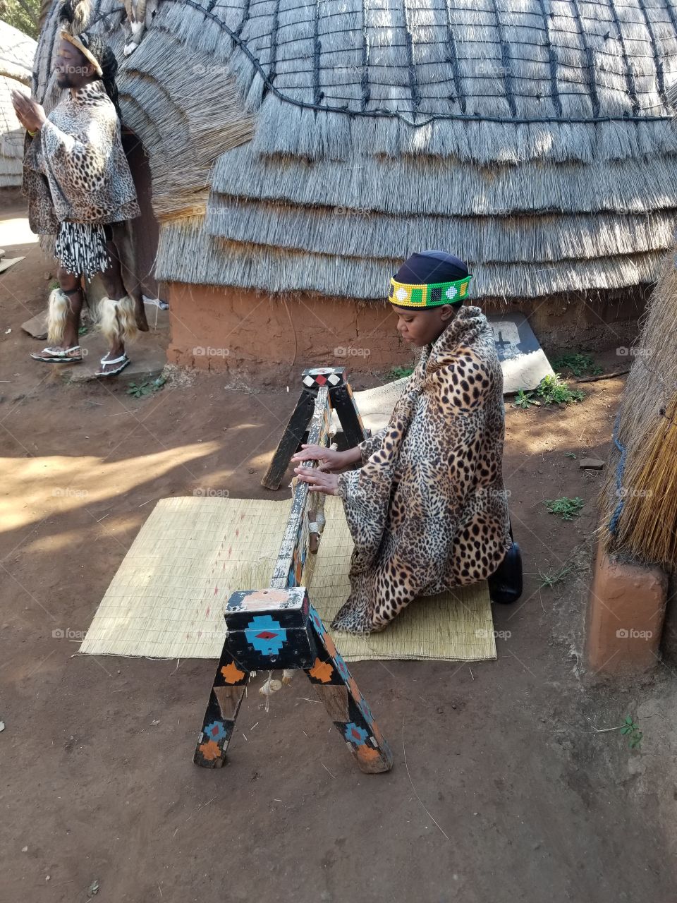 African woman weaves mats