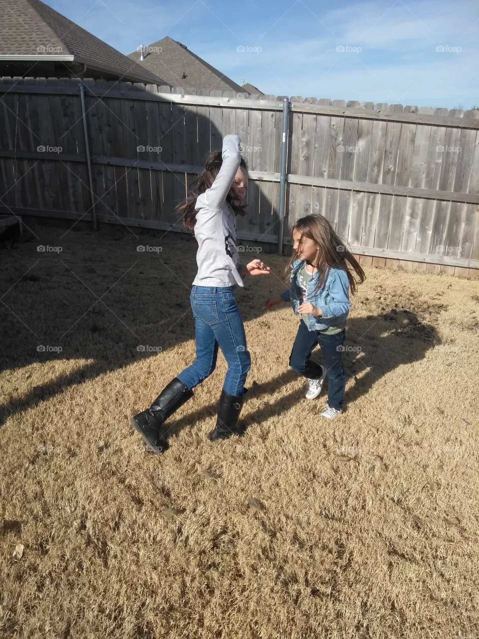 Cousins, Molly (8) & Madison (6) running on the fall grass while playing "tag" in the backyard.