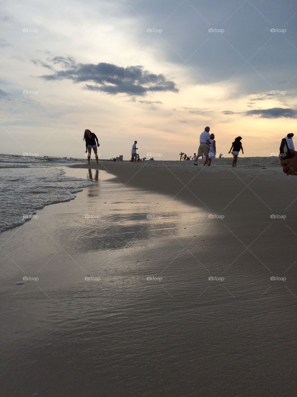 People enjoying a beautiful sunset on a sandy beach