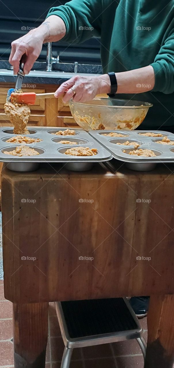 #stayathome - cooking. Filling muffin pans with homemade sweet potato mixture using spatulas.
