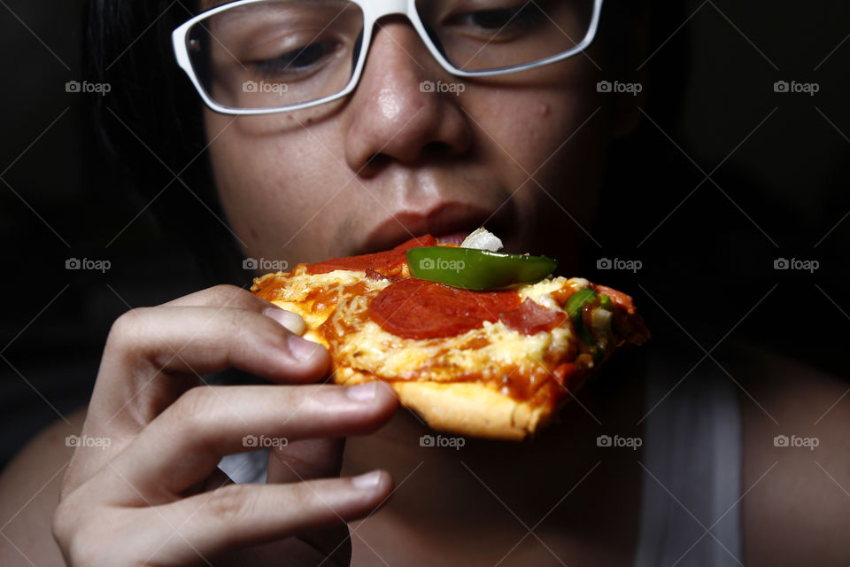 asian teen eating pizza