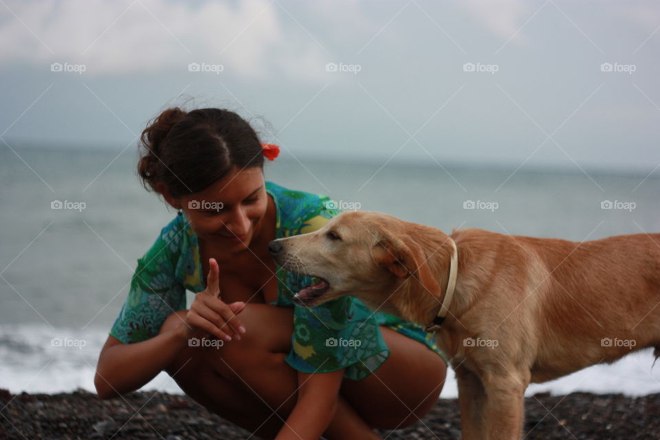 girl playing with dog at the sraside