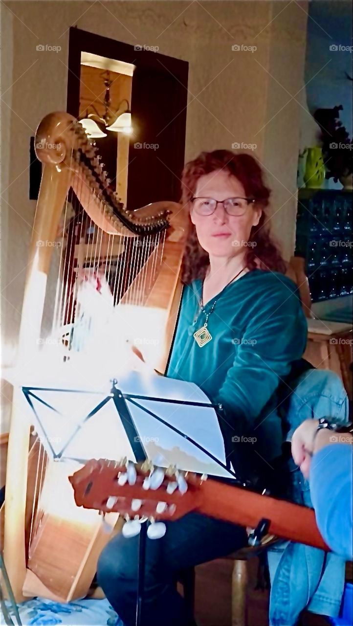 The lovely young lady is playing the harp in a guesthouse in „Bayerischzell“, a small but rather popular township near the Alps in „Bavaria“, Germany. 2024. Hypnotic Productions