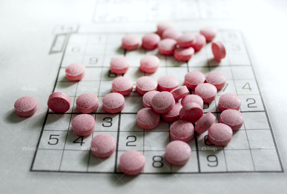 Pink pills and sudoku on the table