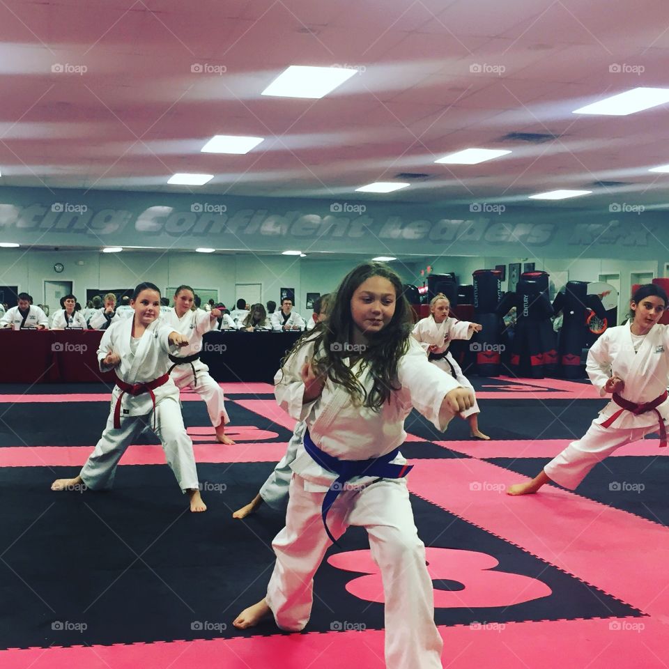 Group of girls practice karate in classroom