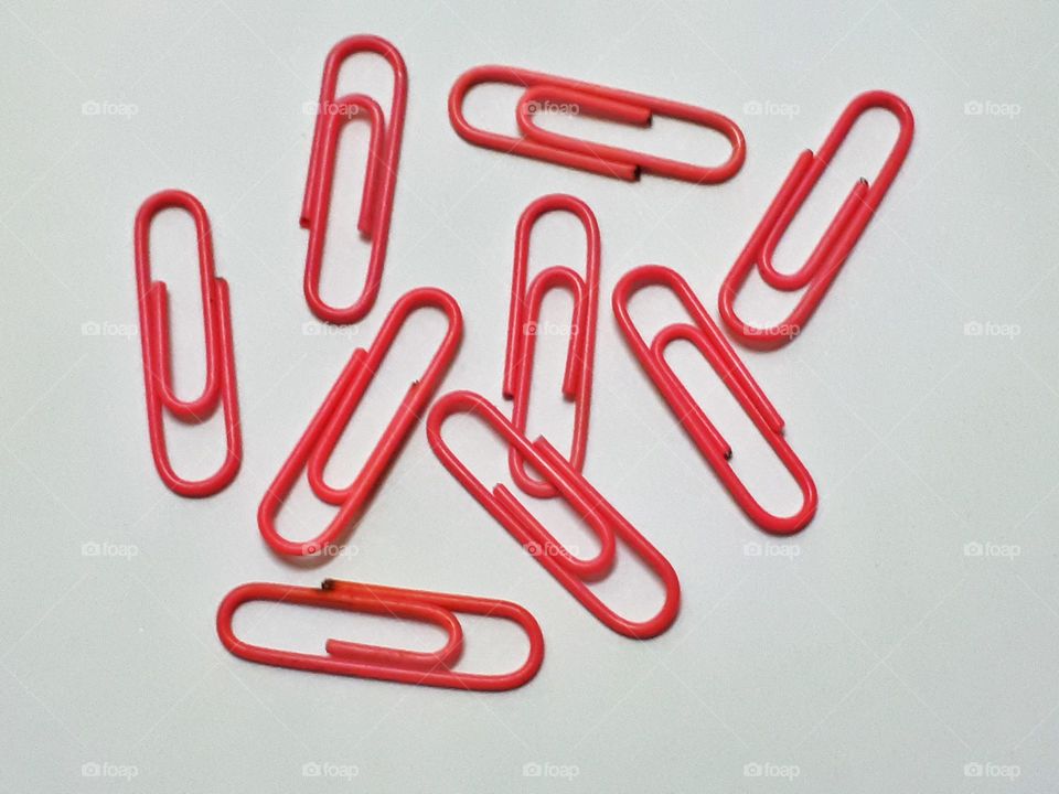 Pink paperclips isolated on white background