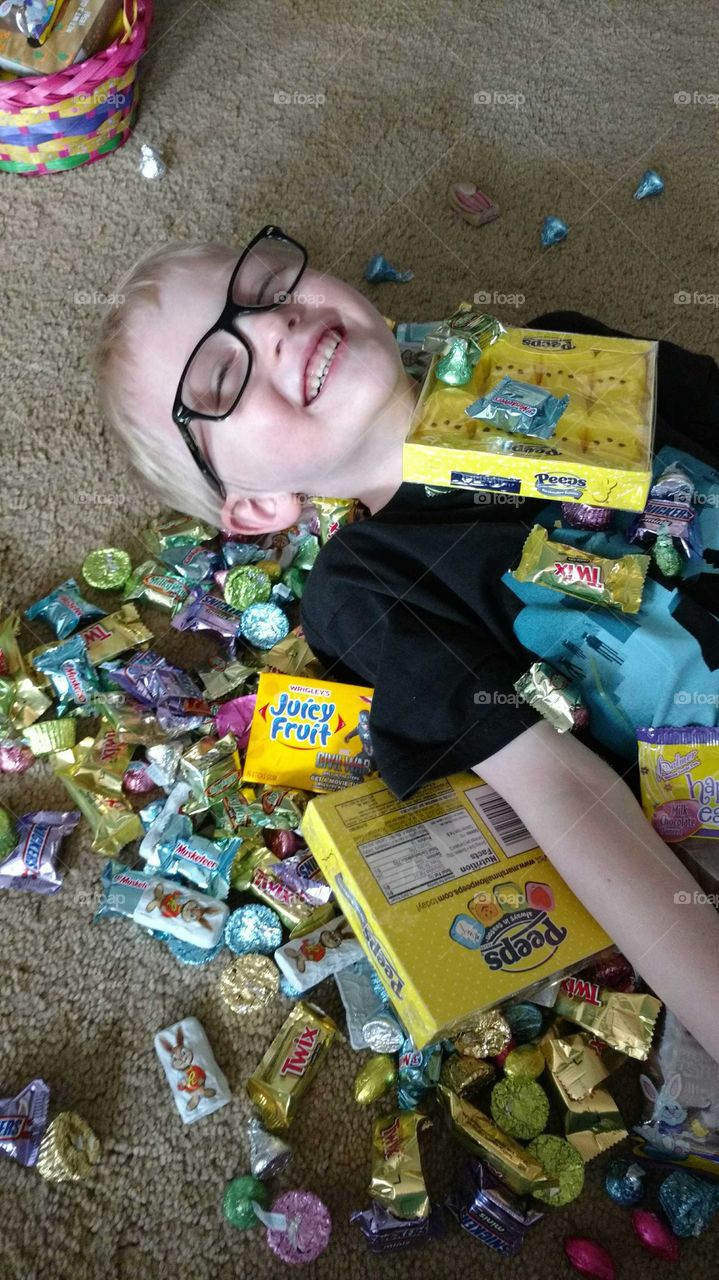 happy boy burried in candy for Easter