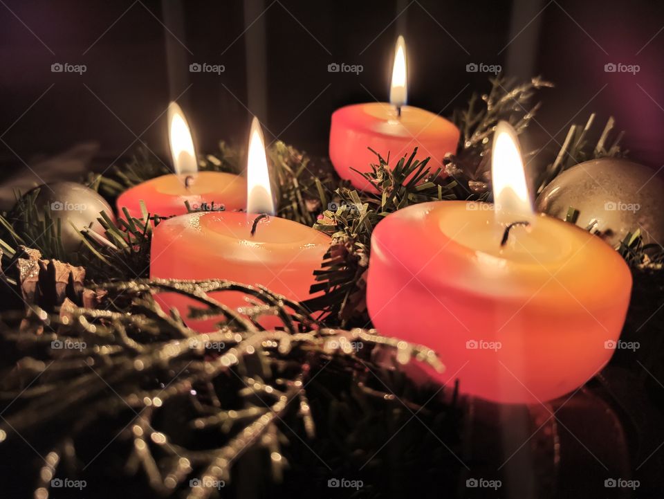 A closeup view of advent wreath with four flamed candles