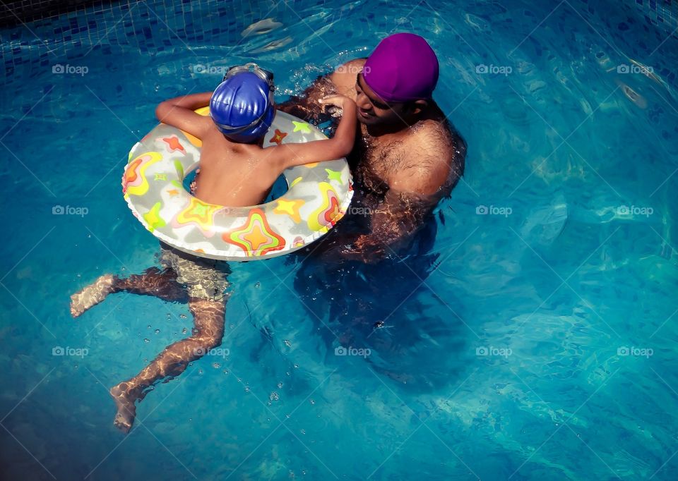 Father training his son to swim