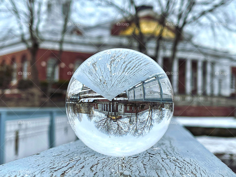A buildings reflection in a glass ball