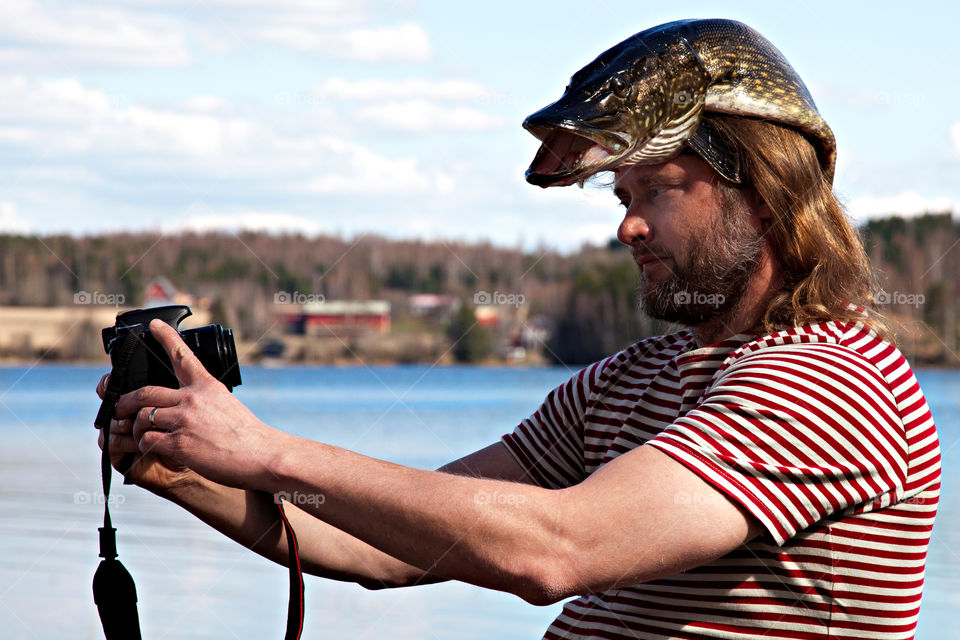Taking a selfie with a fresh pike as a headgear (I am both photographer & fisherman).