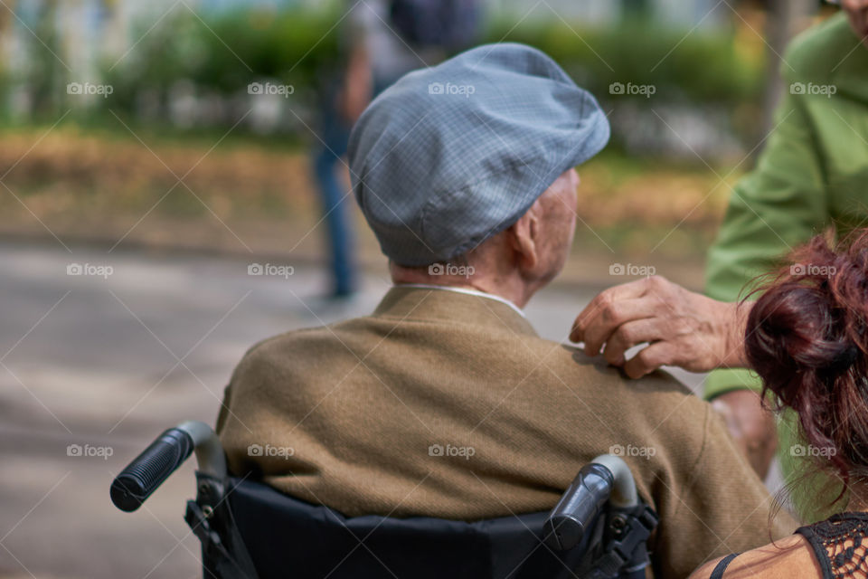 Elderly man with hat sitting in a wheelchair