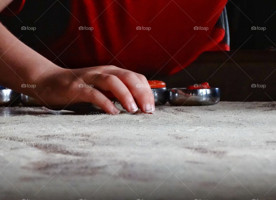 Indoor Shuffleboard. Hand Aiming A Shuffleboard Puck
