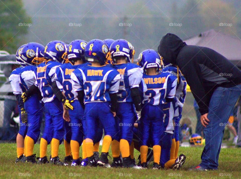 Huddled Up. Pee-wee football team in a huddle. 